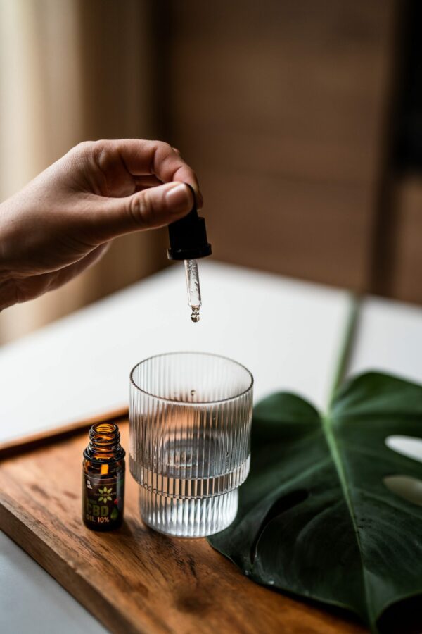 Assortment of NetherLeaf's premium CBD oil products, including bottles of full-spectrum CBD oil, capsules, and topicals, arranged against a backdrop of greenery.